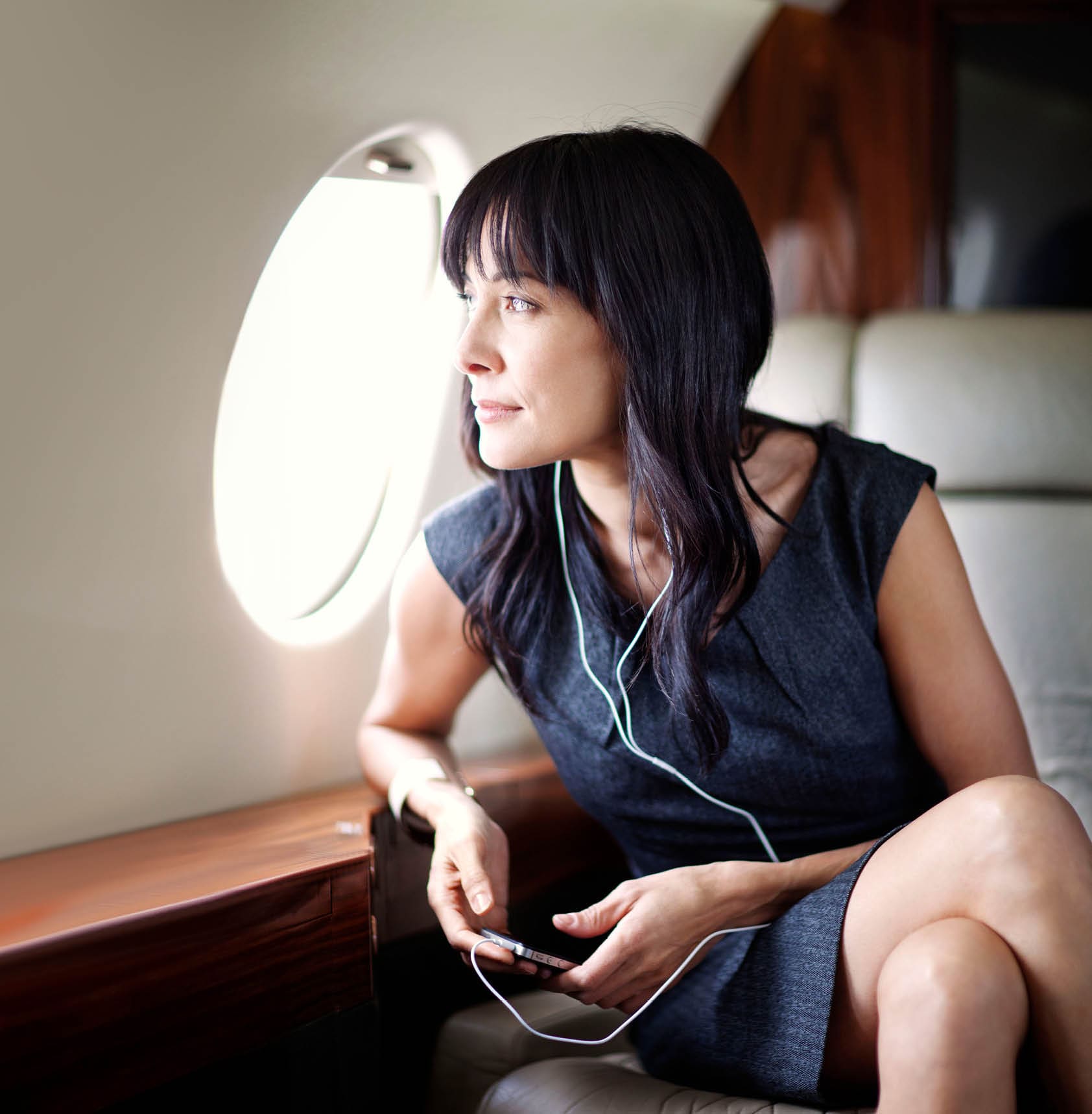 Businesswoman listening to music on a private jet